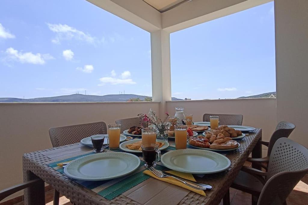 einen Tisch mit Teller mit Speisen auf dem Balkon in der Unterkunft Kristallia apartment with view - Kattavia in Kattavía