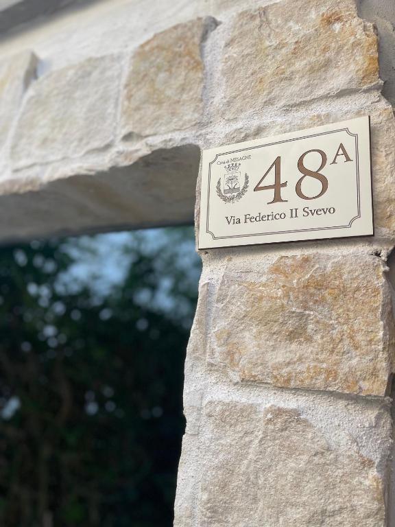 a sign on the side of a stone wall at Casa Angel in Mesagne