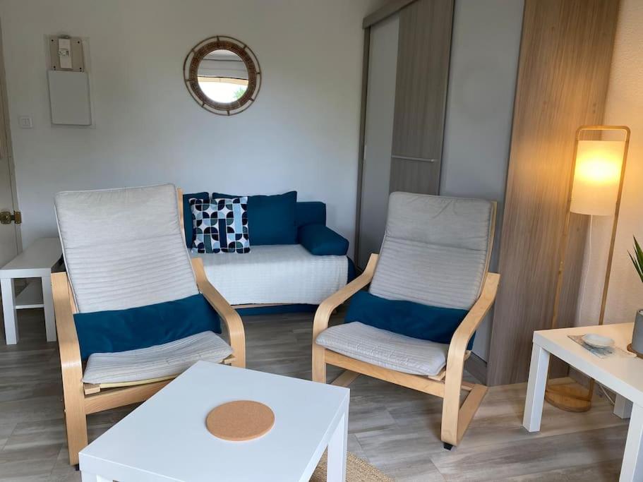 Studio cosy à saint-Pierre la mer في فلوري: غرفة معيشة مع كرسيين وأريكة