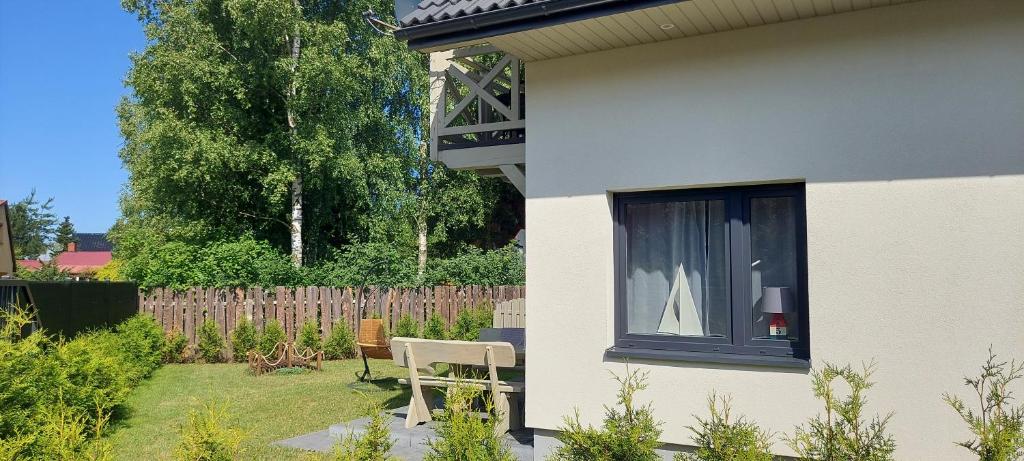 een huis met een raam en een stoel in een tuin bij Całoroczne domki Morska Laguna in Kopalino
