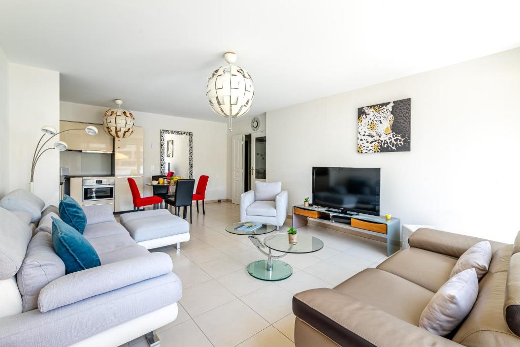 un salon avec des canapés et une télévision à écran plat dans l'établissement Élégant appartement à deux pas du Vélodrome - Emplacement idéal à Marseille, à Marseille