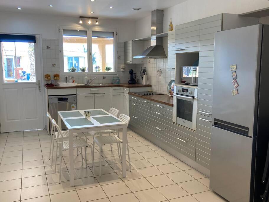 une cuisine avec une table et un réfrigérateur dans l'établissement T3 Leucate bord de mer - Ulysse Naturiste, à Leucate