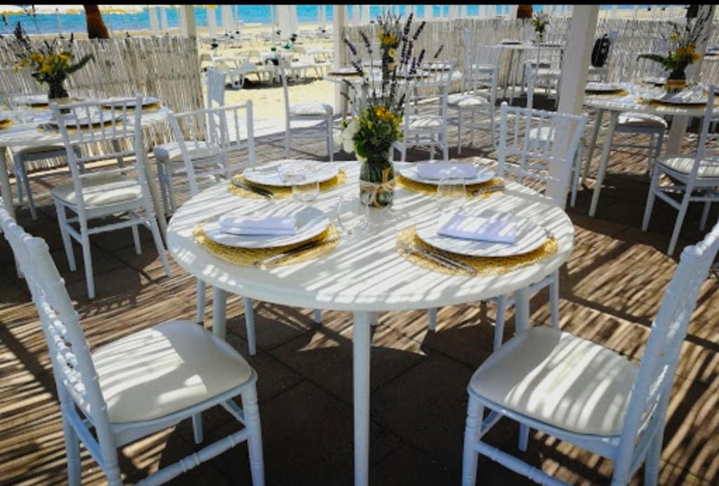 een witte tafel en stoelen met borden en servetten bij La Casa dell'Artista in Marconia