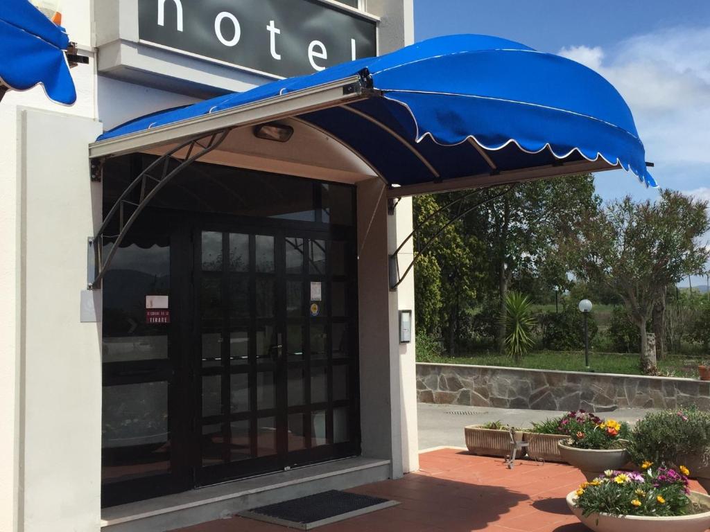 an entrance to a hotel with a blue umbrella at Hotel Letizia in Follonica