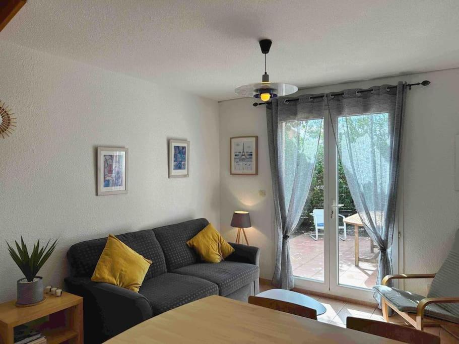 a living room with a couch and a window at Charmante maison à nbne plage in Narbonne