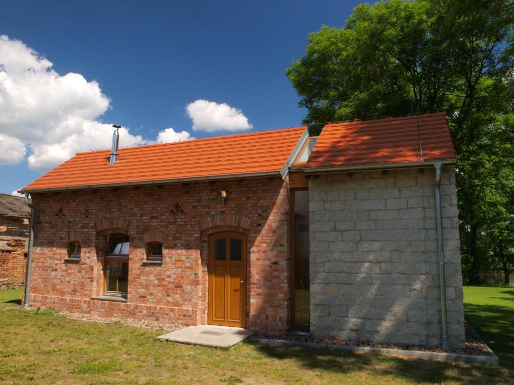a small brick building with an orange roof at Lake House in Kościan