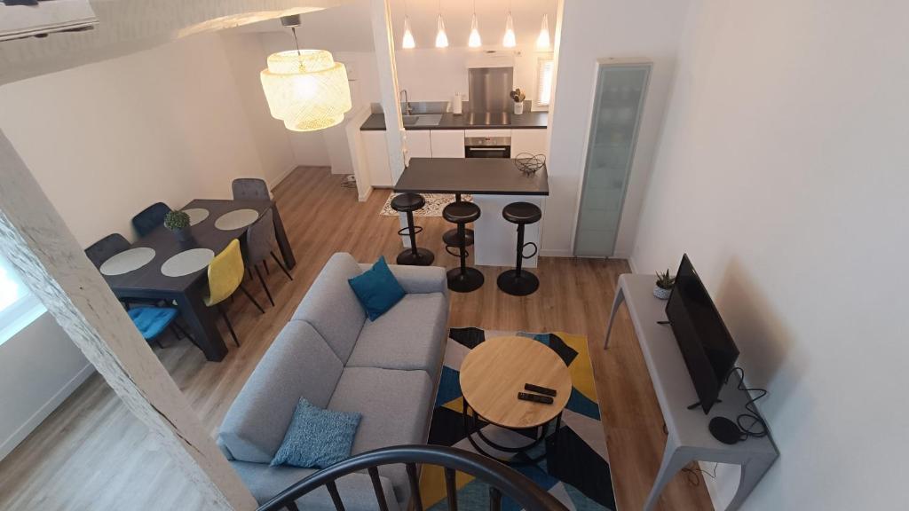 ein Wohnzimmer mit einem Sofa und einem Tisch in der Unterkunft Duplex - Palais de Justice in Toulouse