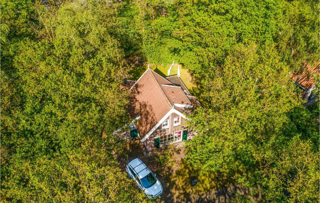 un coche aparcado frente a una casa en los árboles en Buitengoed Het Lageveld - 75 en Hoge-Hexel