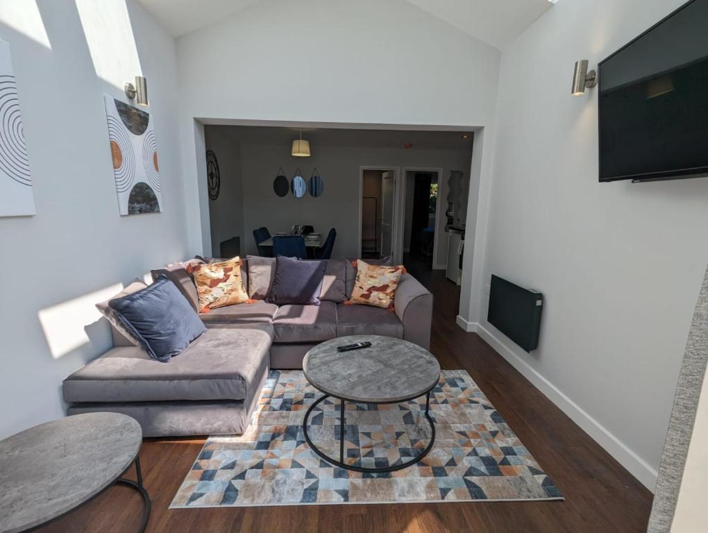 a living room with a couch and a table at Kinetic Stays - Serenity Holiday Cottages in Sidmouth