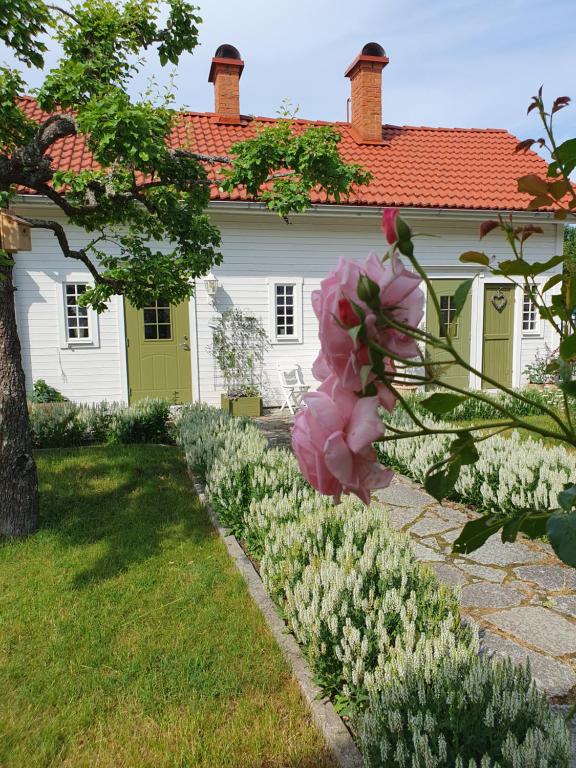 een huis met een bloementuin ervoor bij Stenkullens gårdshus in Borensberg