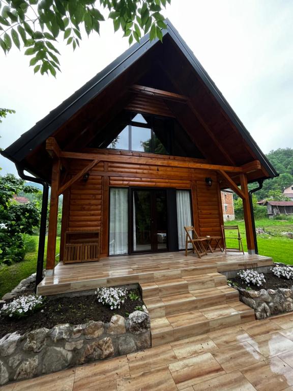 eine Blockhütte mit einer Terrasse und einem Haus in der Unterkunft Šum Rzava 2.0 in Arilje