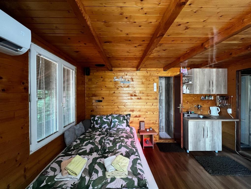 ein Schlafzimmer mit einem Bett in einer Holzhütte in der Unterkunft Kuca i splav na reci Savi in Belgrad
