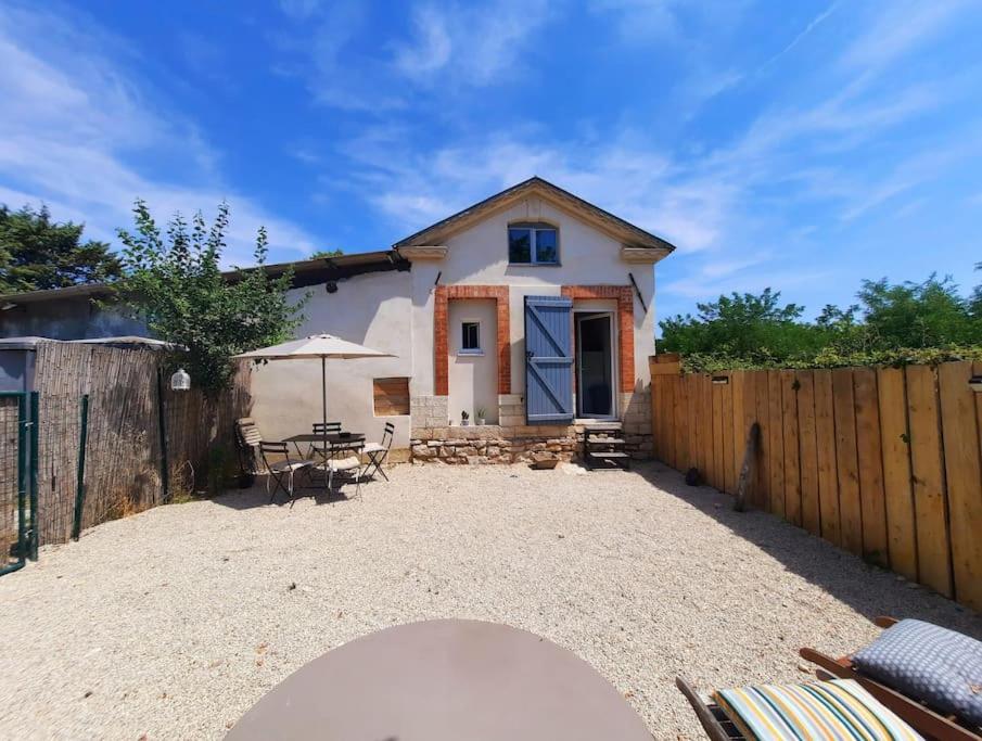 una casa con una valla, una mesa y una sombrilla en adorable guest house avec jardin et parking privatif, en Aix-en-Provence
