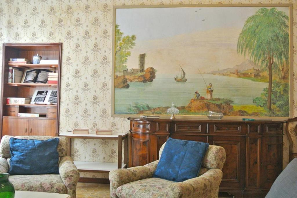 een woonkamer met 2 stoelen en een schilderij aan de muur bij Gramsci Home in Volterra