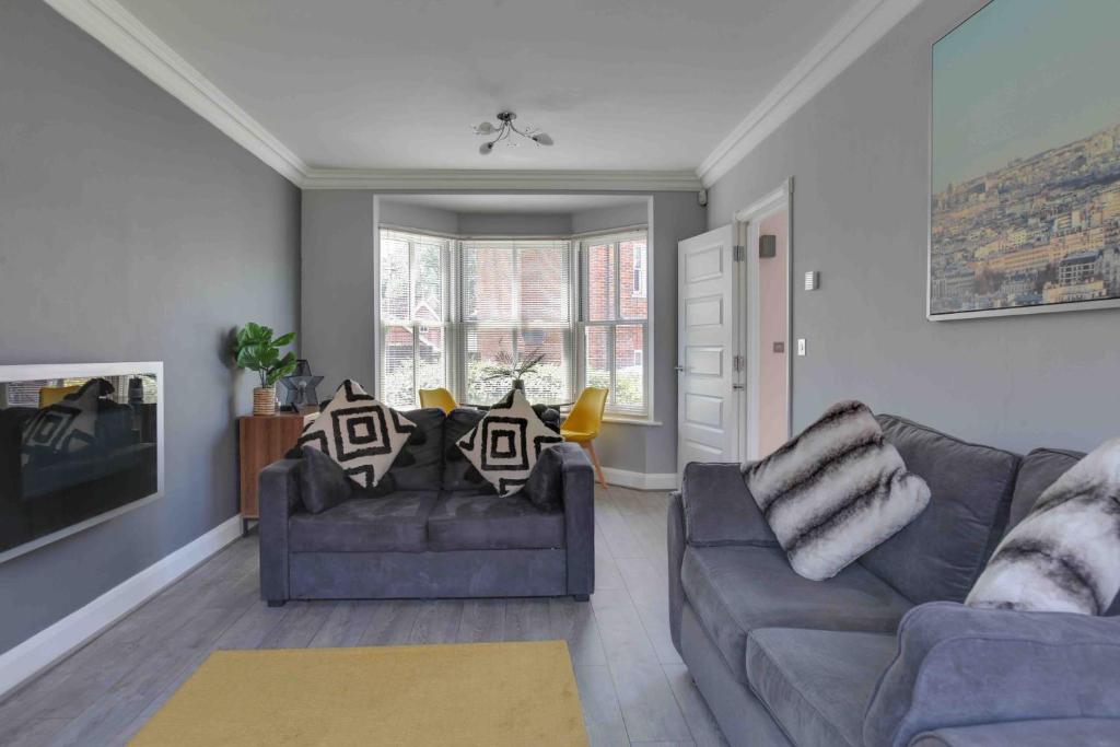 uma sala de estar com dois sofás e uma televisão em Elizabeth II Five Bedroom Spacious Home 