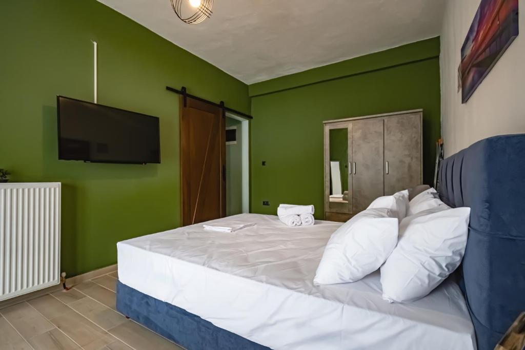 een slaapkamer met een wit bed en groene muren bij One Salonica Deluxe Apartment 1 in Thessaloniki