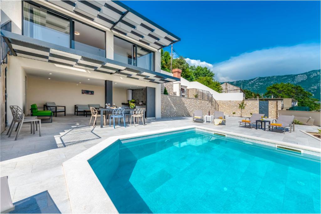 a villa with a swimming pool and a patio at Holiday home Perko in Dunave Krajnje