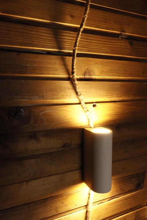 a light hanging from a wooden wall with a candle at EcoXata in Slavske