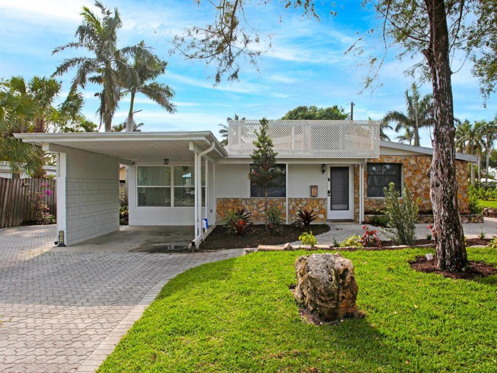 una casa bianca con un albero nel cortile di Lake Park Cottage a Naples
