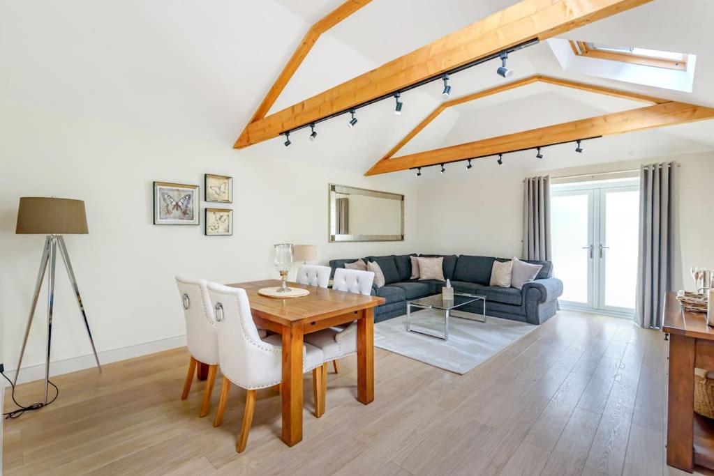 a living room with a table and a couch at The Cowshed in Farmborough