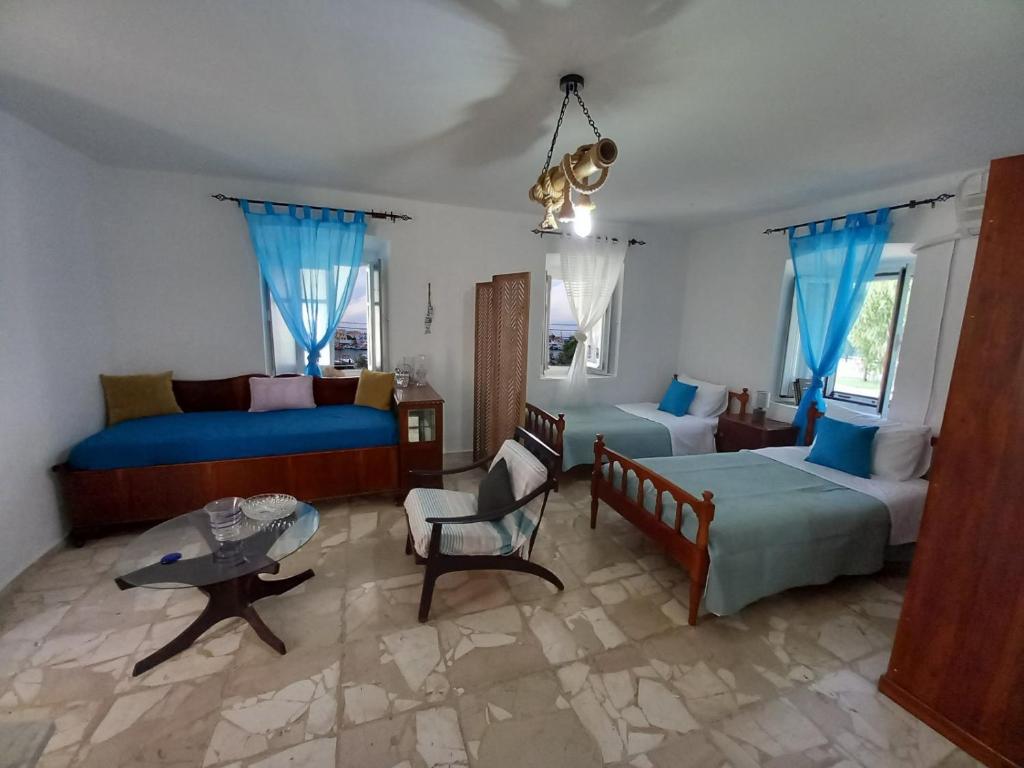 ein Schlafzimmer mit einem Bett, einem Sofa und einem Tisch in der Unterkunft Anezo's Exceptional View in Spetses