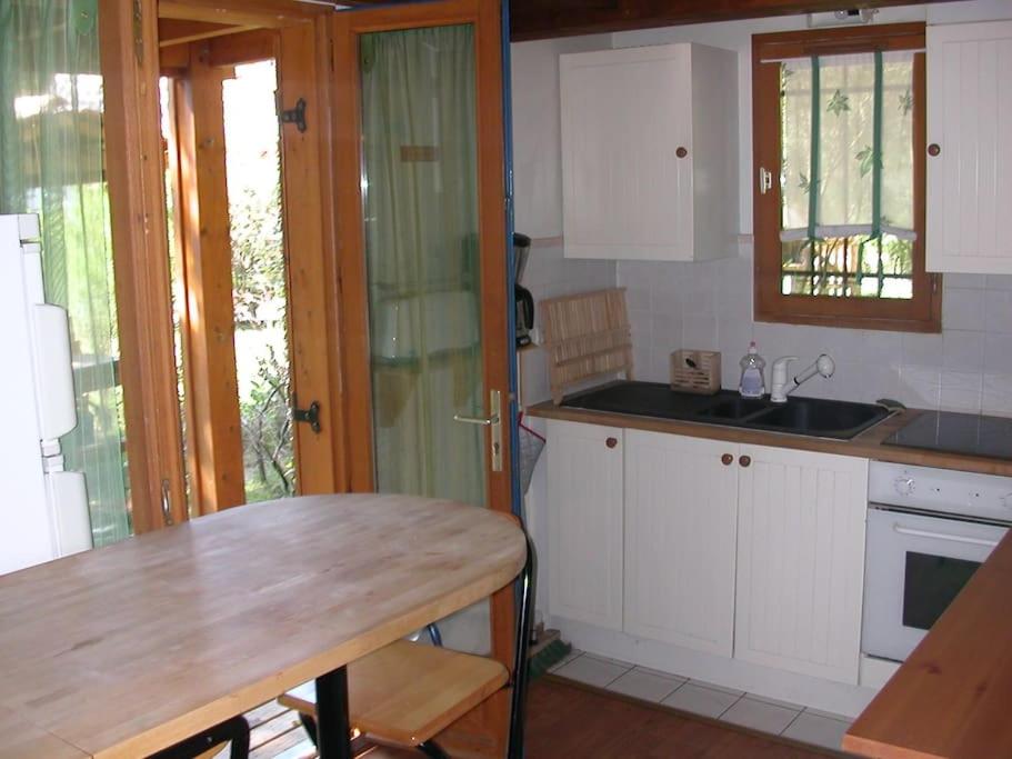 una cucina con armadi bianchi e tavolo in legno di Chalet Bassin d'Arcachon a La Teste-de-Buch