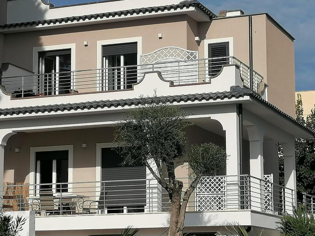 Casa grande con escaleras y balcón. en Alloggio turistico Lido delle Sirene, en Anzio