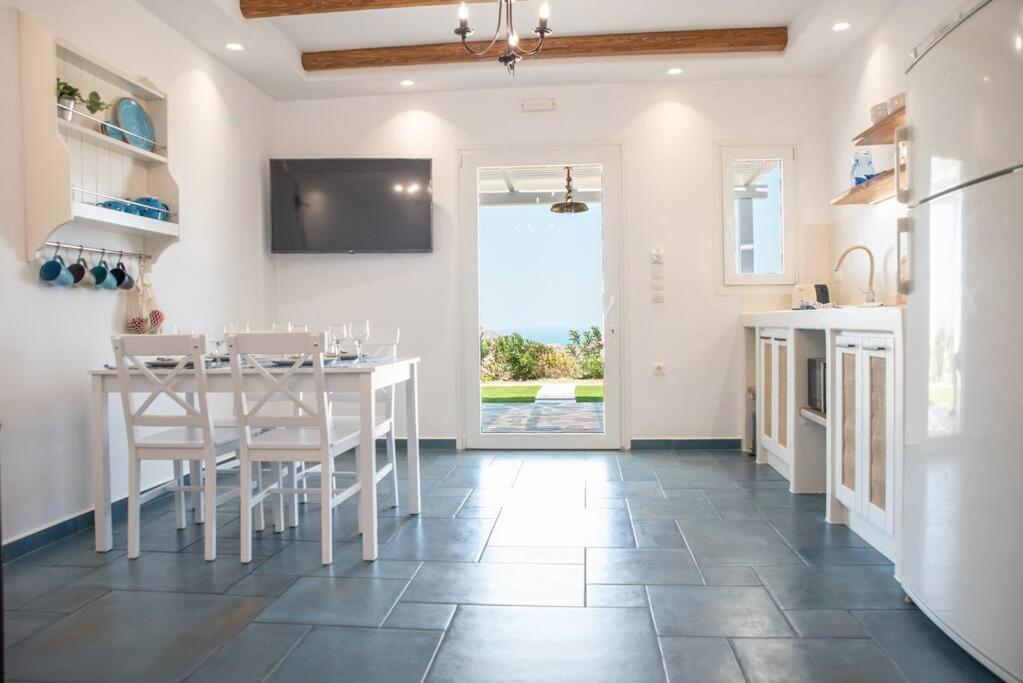 a kitchen and dining room with a table and chairs at VAGIANOU THEA celeste in Vívlos
