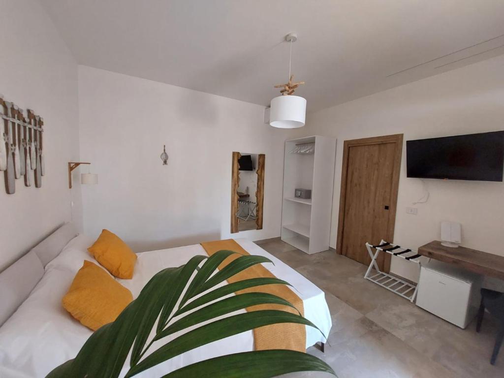 Habitación blanca con cama y TV en Le Barche Volanti, en Lampedusa