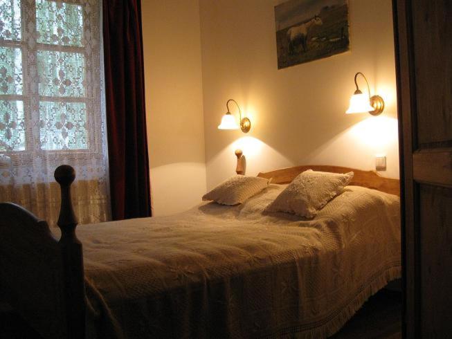 1 dormitorio con 1 cama con 2 almohadas y ventana en Villa Stare Osieczno, en Stare Osieczno
