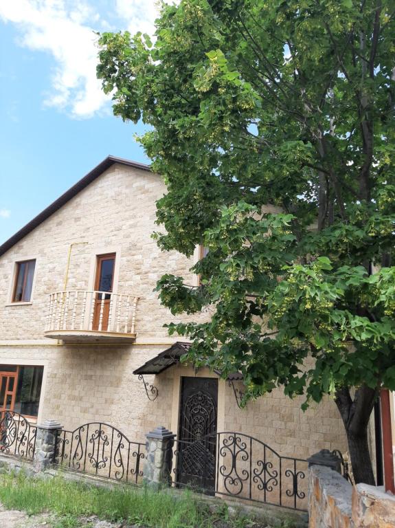 an old house with a tree in front of it at Shen toon guesthouse in Shnogh