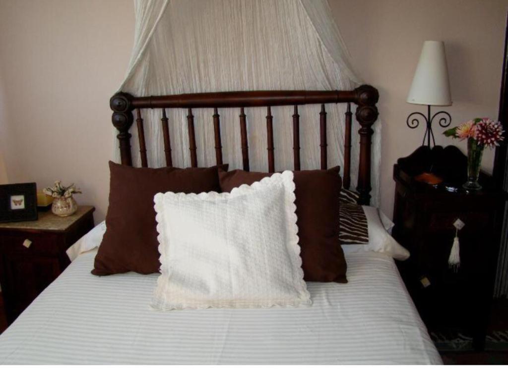 een bed met bruine en witte lakens en kussens bij casa cumial in Ourense