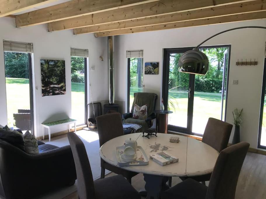 - un salon avec une table et des chaises dans l'établissement Log cabin rural retreat in beautiful countryside, à Lapworth