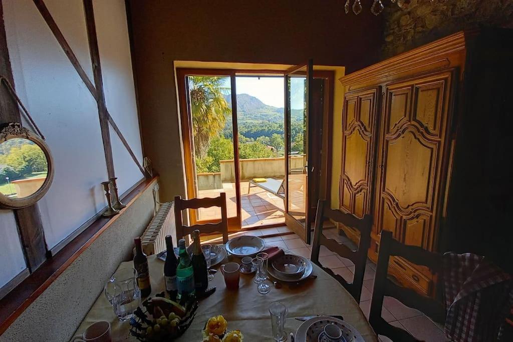 una mesa con comida en ella en una habitación con ventana en Loft rural - terrasse parking et vue en Ferrières-sur-Ariège