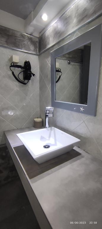 a bathroom with a white sink and a mirror at olivegrove in Sidari