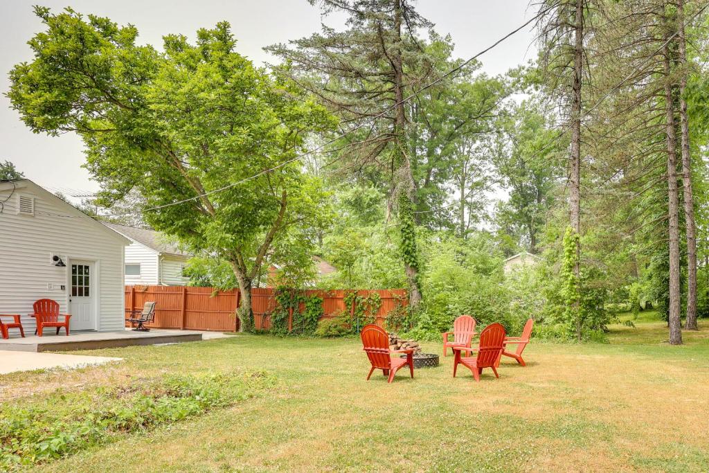 un groupe de chaises rouges et une table dans une cour dans l'établissement Chippewa Lake Cottage with Fire Pit!, à Chippewa Lake