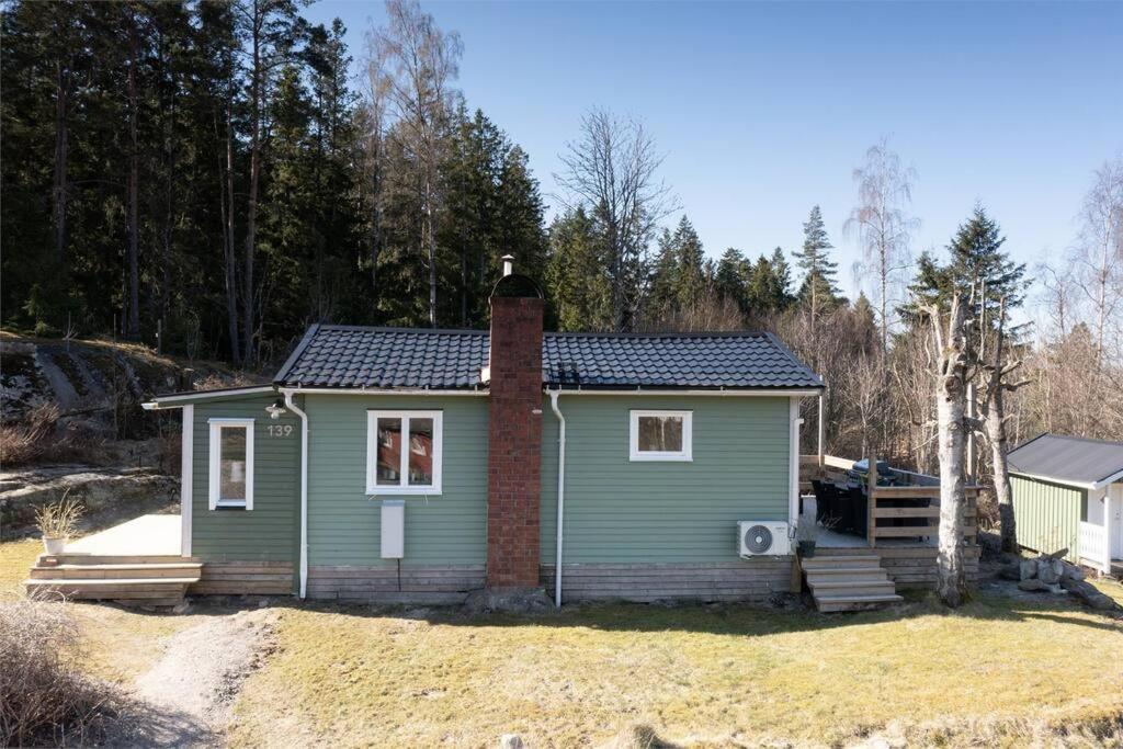 a small green house on top of a field at Jättemysig villa in Uddevalla