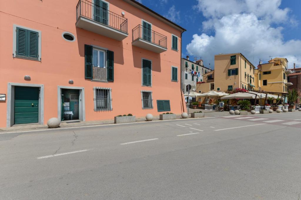 an empty street in a town with a pink building at Appartamento sul Mare a Rio Marina, Isola d'Elba in Rio Marina