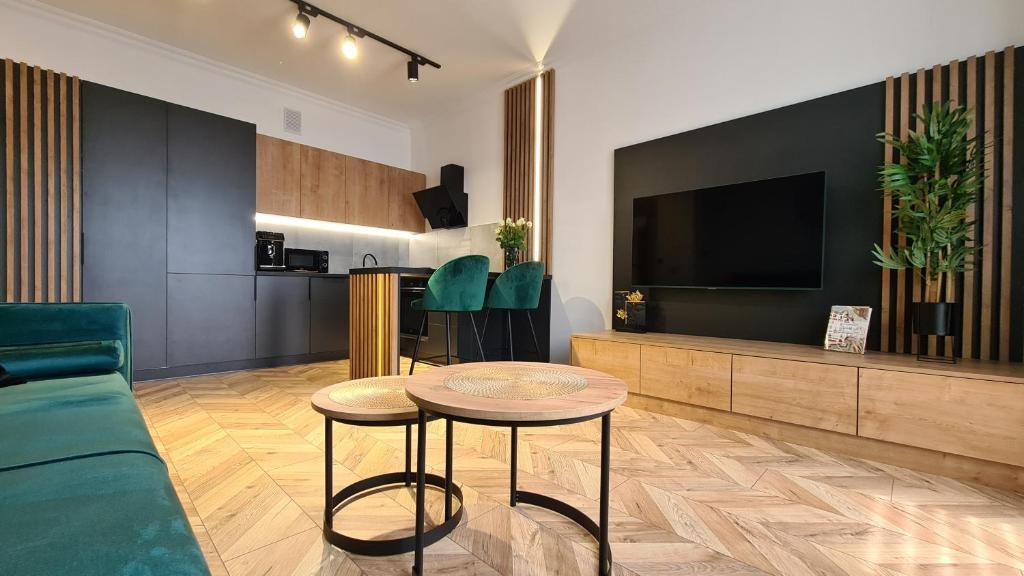 een woonkamer met een tafel en een televisie bij Apartament PRIMO in Zamość