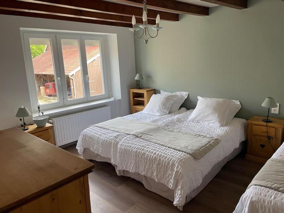 a bedroom with two beds and a window at Maison de campagne rénovée 