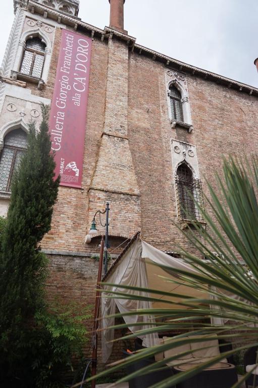 a building with a sign on the side of it at Pesaro Palace in Venice