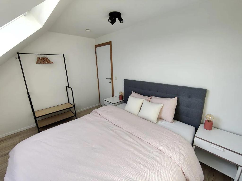 um quarto com uma cama grande com lençóis brancos e almofadas em Bel-etage Bruges Homestay - Free parking - Entire floor em Bruges