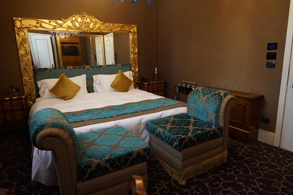 a bedroom with a bed and a mirror and a chair at Pesaro Palace in Venice