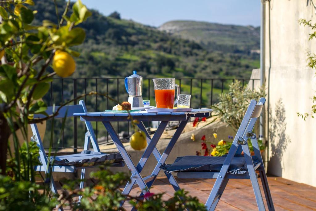 una mesa azul con una bebida en la parte superior de un balcón en B&B Giardino Di Pietra en Ragusa
