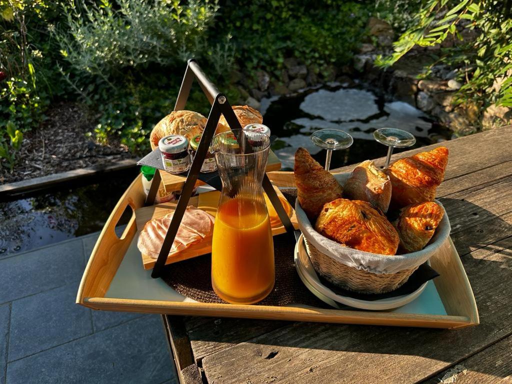 een dienblad met brood en sinaasappelsap op een tafel bij Ô nature in Grez-Doiceau