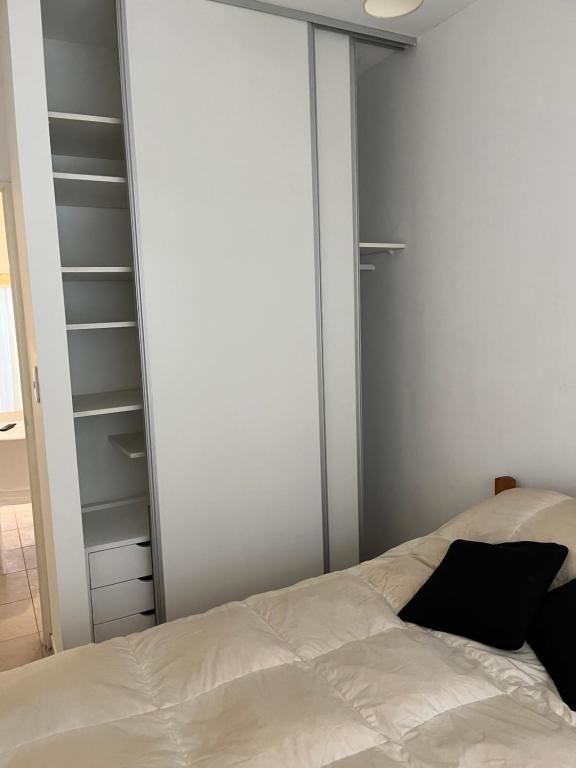 1 dormitorio con cama blanca y armario en Naon en Buenos Aires