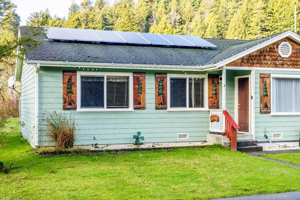 ein Haus mit Sonnenkollektoren darüber in der Unterkunft Elk Meadow Cabins 13A Bears Den Suite in Orick