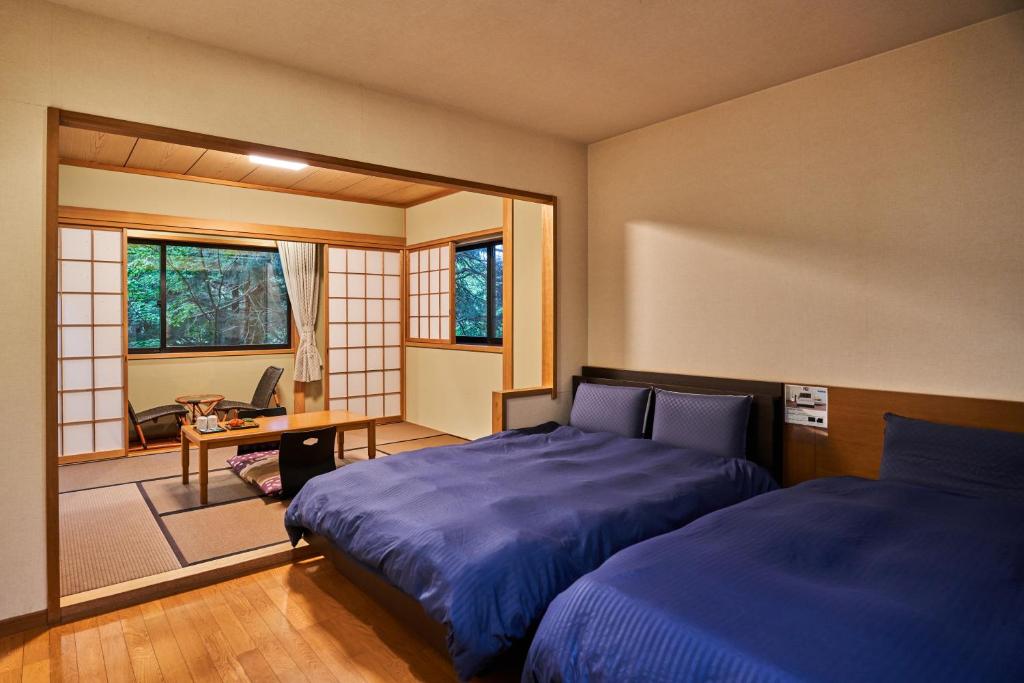 Una cama o camas en una habitación de Ajisai Onsen Ryokan - Award Winning Private Open Air Onsen