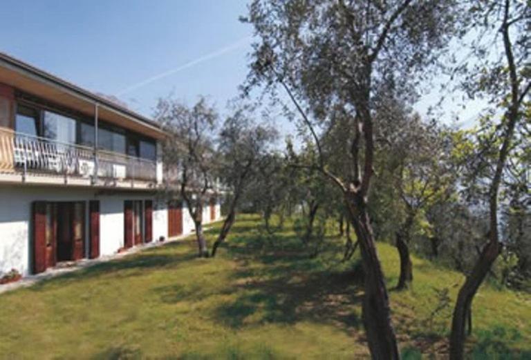 a building with a yard with trees next to it at Appartamento B&B Preone in Limone sul Garda