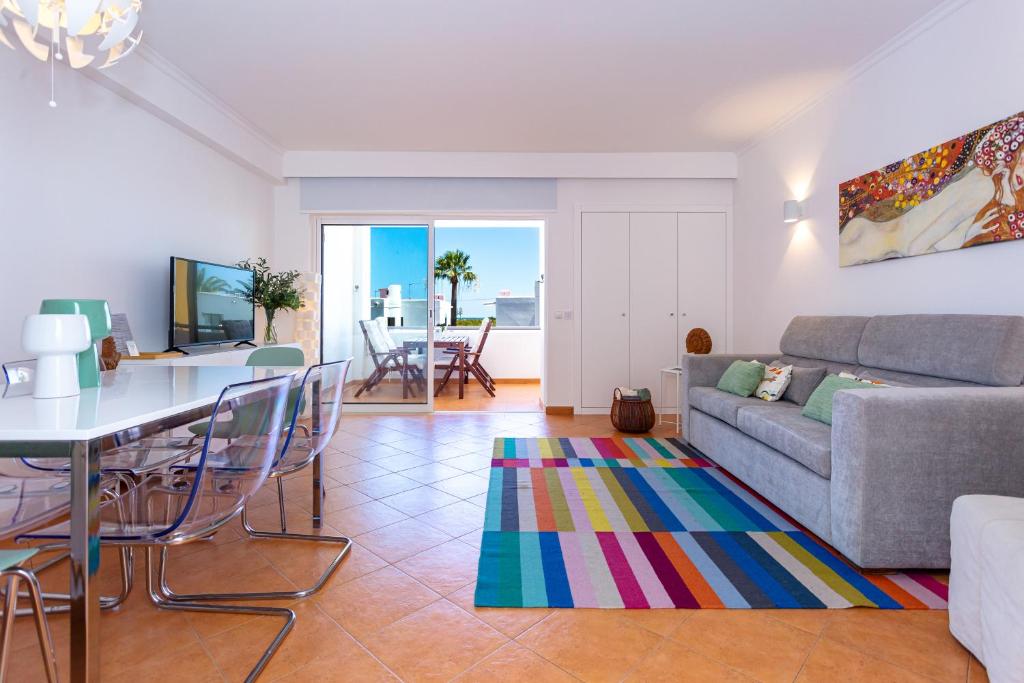uma sala de estar com um sofá e uma mesa em Cabanas Sea View APT in Golden em Cabanas de Tavira
